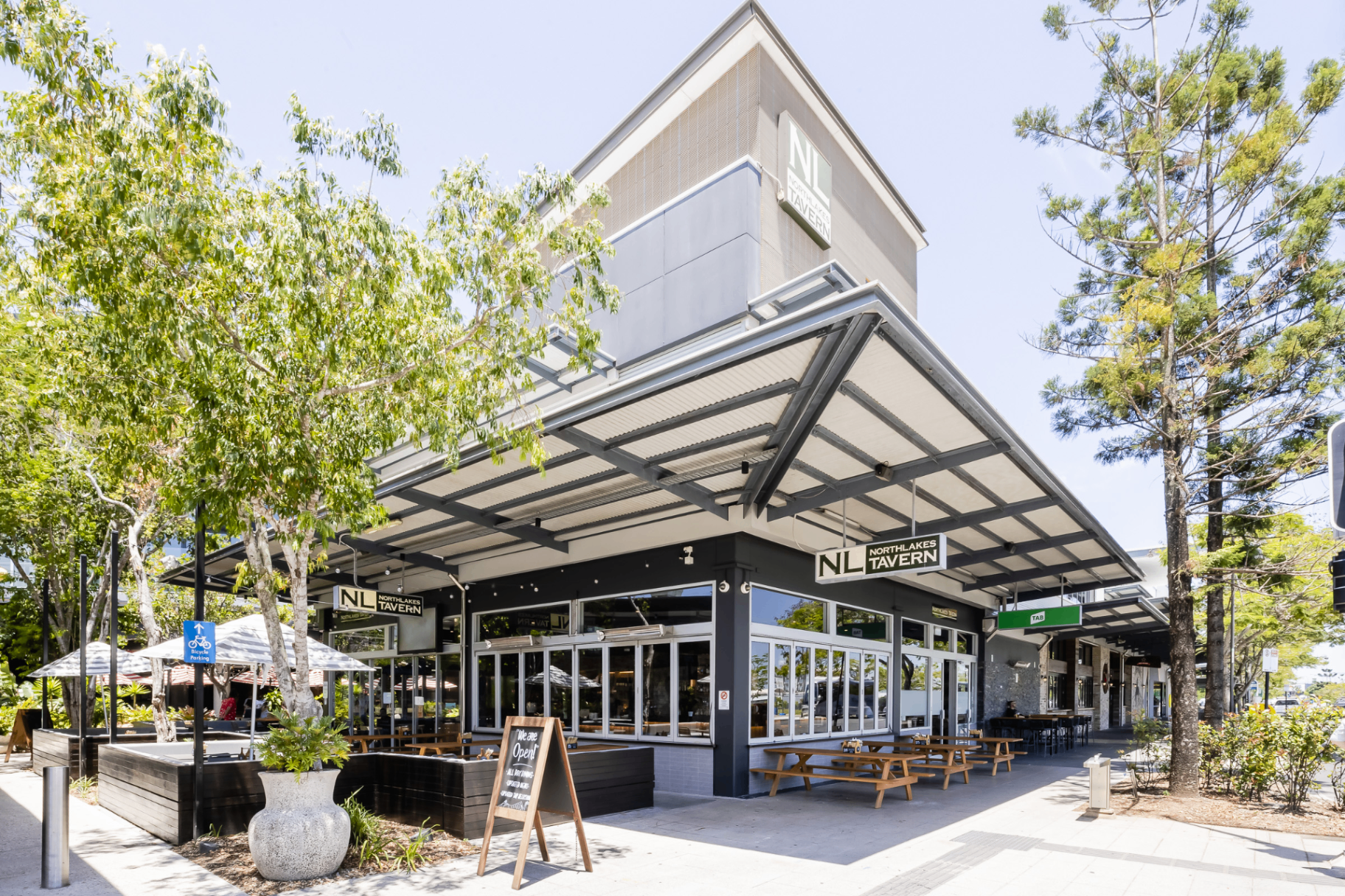 North Lakes Tavern exterior with outdoor seating and leafy trees