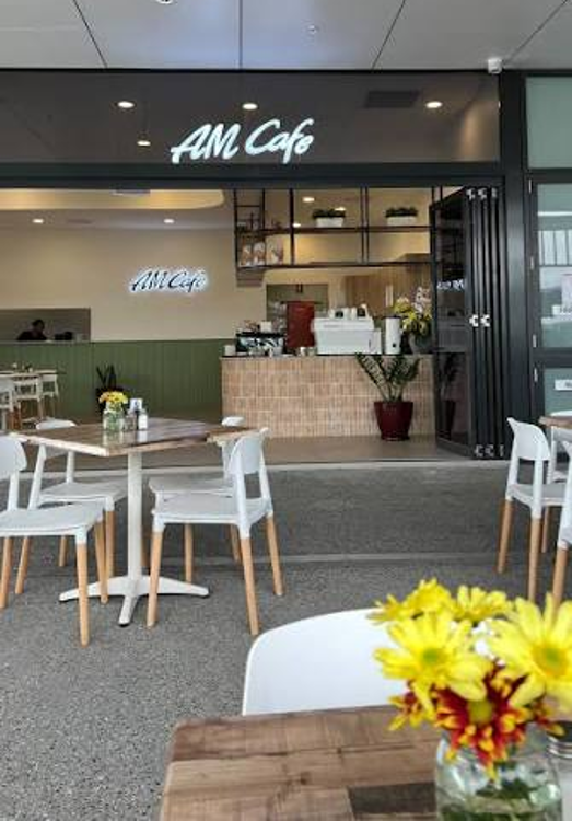 AM Cafe at Warbu Bellmere Shopping Village with outdoor tables and flowers