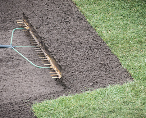 Under turf soil being spread and levelled beside existing lawn